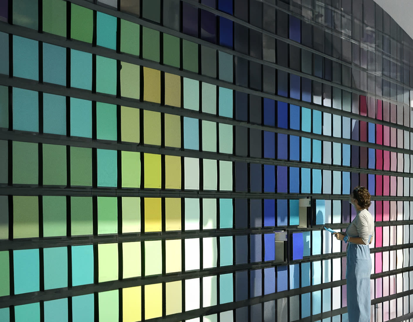 Image of a woman standing in front of a colorful wall of color samples.